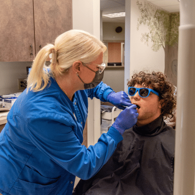Teenage boy wearing sunglasses while undergoing orthodontic treatment, representing sports season