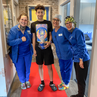 Teenager patient posing with dental team, representing braces for teens