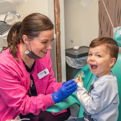 A dental team member talking to a child, representing teething pain in babies