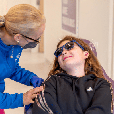 Dentist talking to a little girl about to have her teeth worked on, representing when should kids go to the dentist