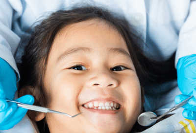 Child smiling at dental appointment, representing what to expect at the first pediatric dental visit