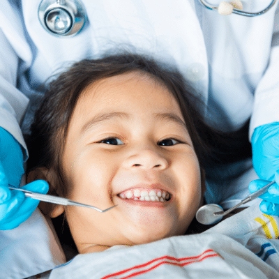 Child smiling at dental appointment, representing what to expect at the first pediatric dental visit