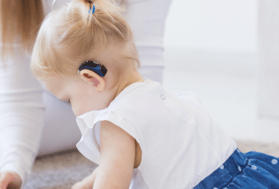 Child exploring a book on floor representing bi-specialty dental care for kids with special needs