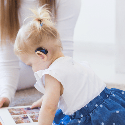 Child exploring a book on floor representing bi-specialty dental care for kids with special needs